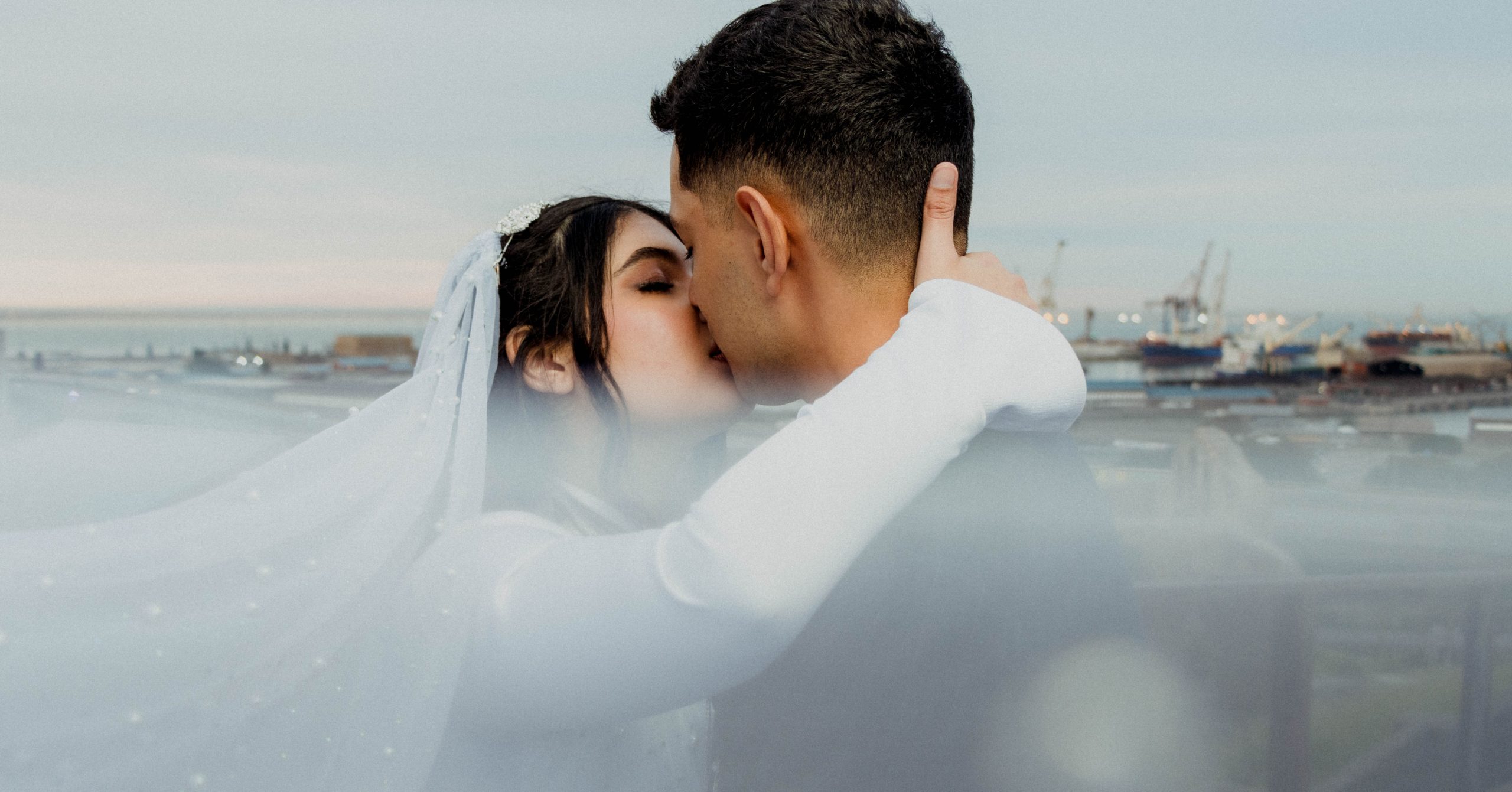 Bride and groom kissing while overlooking harbour in Port Elizabeth